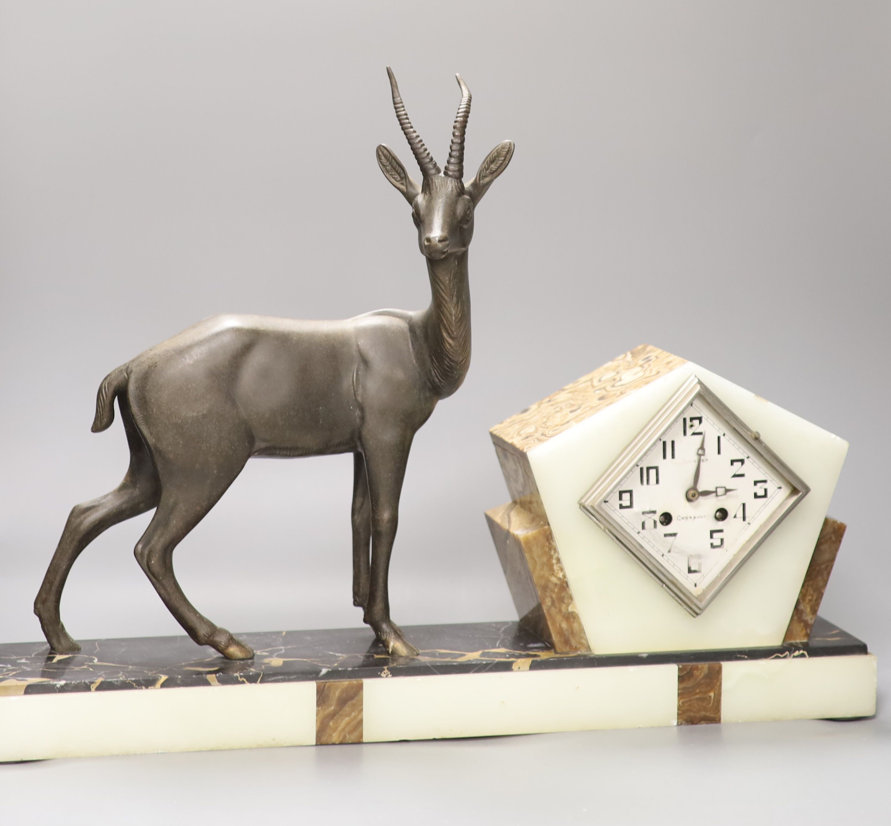 An Art Deco spelter, marble and onyx 'antelope' mantel clock, length 58cm